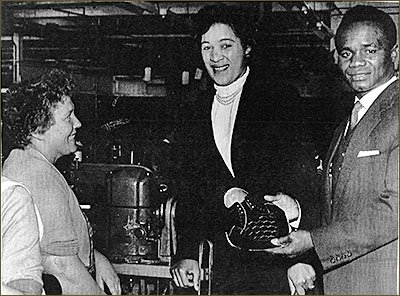 Photograph showing Hogan "Kid" Bassey visiting Coles Boot Co in the late 1950s meeting a 'sample hand', Marjorie Evans