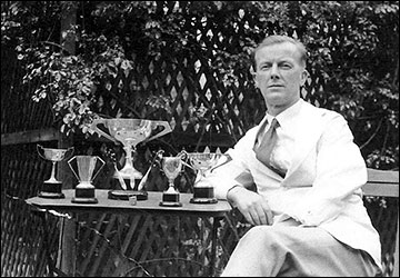 Albert Cooke with darts trophies