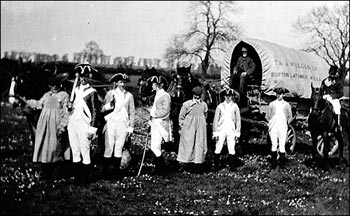 Photograph showing an unknown historical enactment event featuring a miller's cart.  The waggoners are wearing the traditional waggoner's smock.