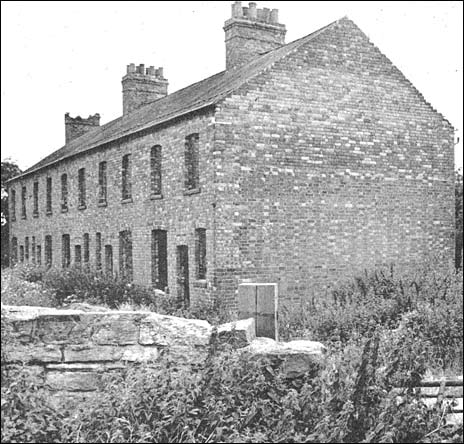Photograph showing the row of derelict houses before getting a new lease of life