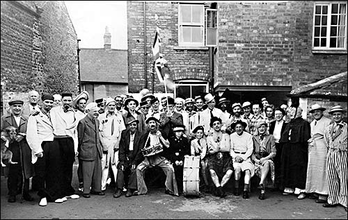 Photograph of the Jockey regulars and visitors  in fancy dress in the pub yard c1950
