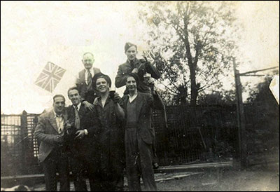 Photograph showing group with landlord apparently celebrating some World War 2 event.