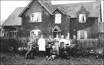 Standing L - R: Mr. Pike (a live-in farm worker), unknown, unknown, Louisa Downing (Bill Ross&rsquo;s step-grandmother), Polly Downing, Alice Downing and Nell Downing. Seated are: Fred Downing and Rosa Downing.
